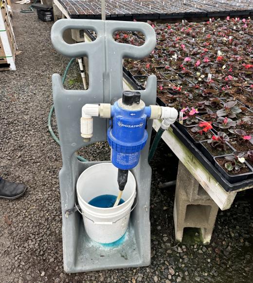 A mobile fertilizer proportioner mounted on a dolly for spot fertilization